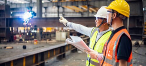 Two construction workers in steel factory