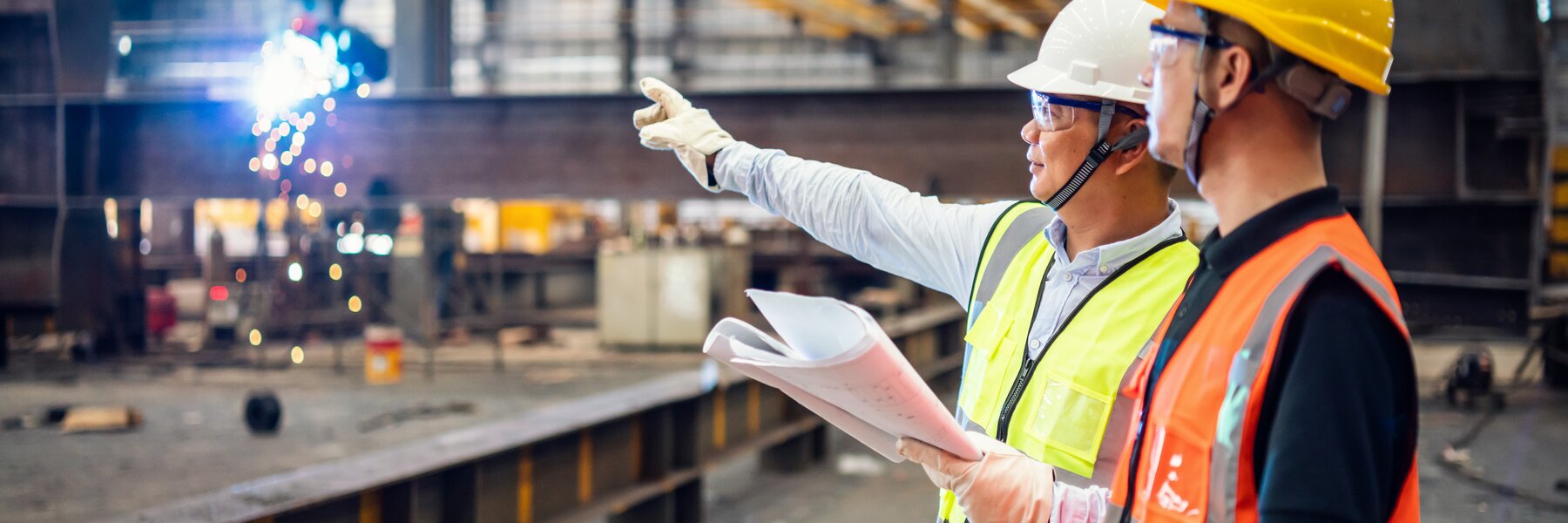 Two construction workers in steel factory